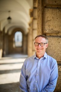 profile photo of the Provost in the cloister by Fisher Studios