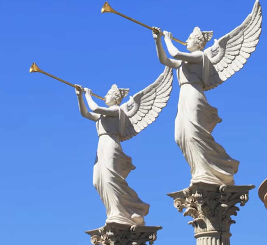 Blue sky background with angel statues blowing golden horns