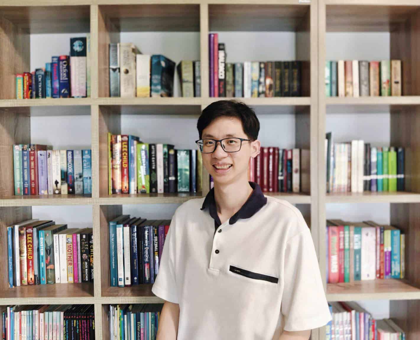 Sapolnach profile photo: he stands in front of a bookcase