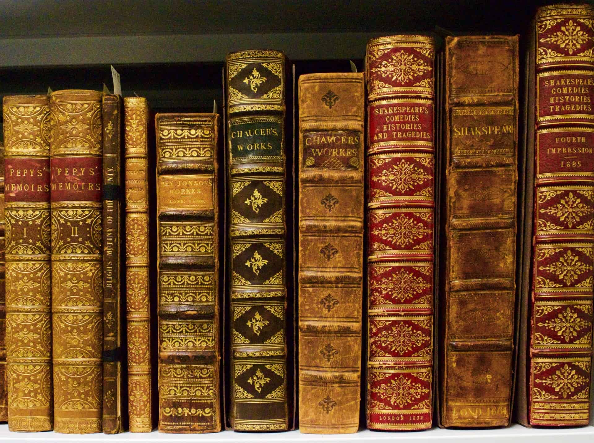 Row of old English books on book shelf