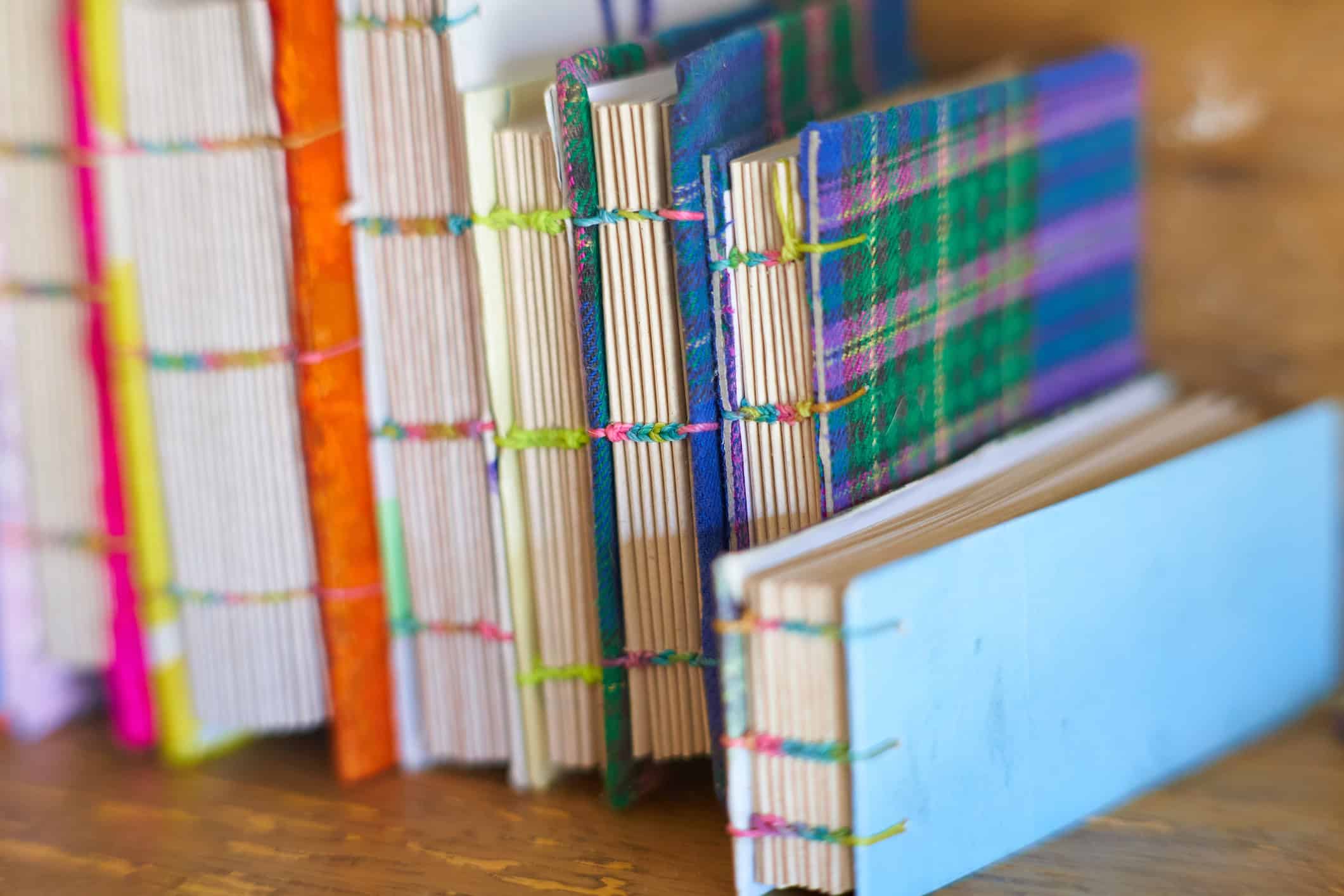 spines of hand-bound notebooks with recycled materials